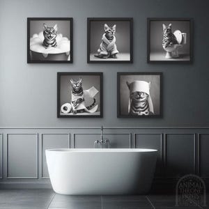 May include: A set of five black framed prints featuring a cat in various humorous situations. The cat is wearing a bathrobe, taking a bath, using toilet paper, and wearing a blindfold. The prints are all in black and white.