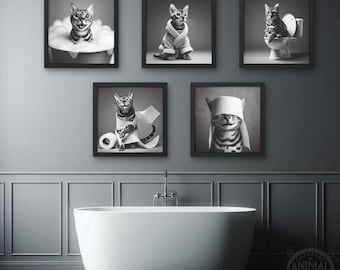 May include: A set of five black framed prints featuring a cat in various humorous situations. The cat is wearing a bathrobe, taking a bath, using toilet paper, and wearing a blindfold. The prints are all in black and white.