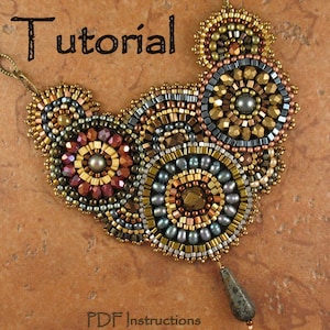 Könnte beinhalten: Eine Perlenkette mit geometrischem Muster in Gold-, Braun- und Grautönen. Die Kette hat einen großen Anhänger mit einem tropfenförmigen Stein. Der Text "Tutorial" und "PDF-Anleitung" ist auf dem Bild zu sehen.