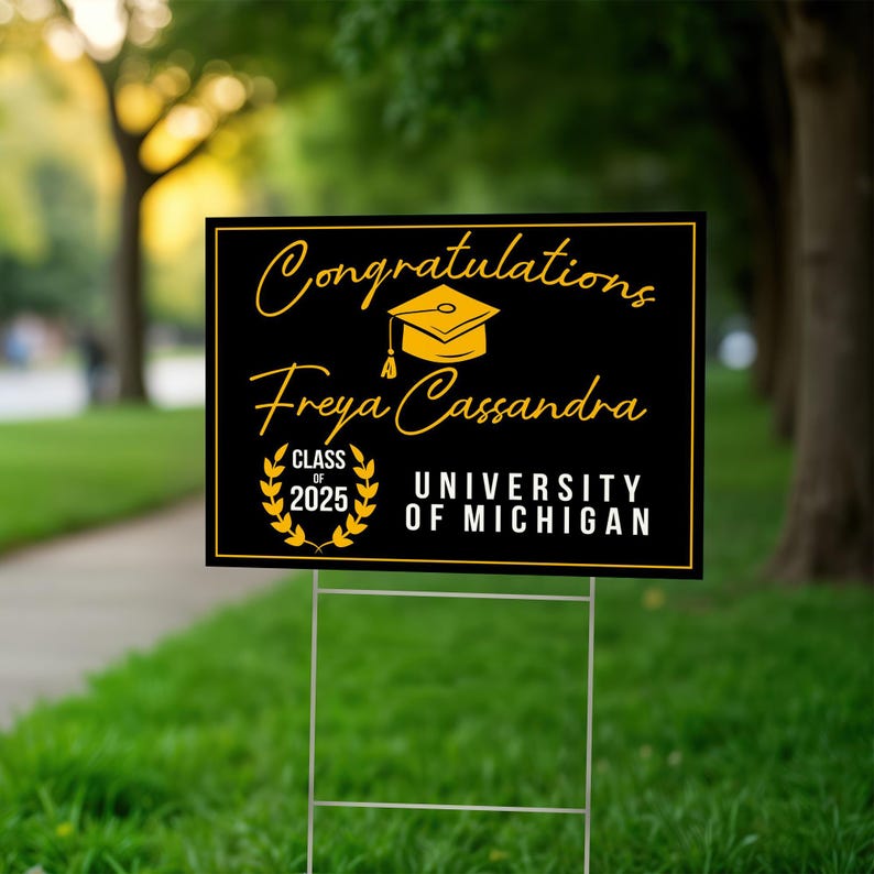 K&ouml;nnte beinhalten: Schwarzes und goldenes Graduation-Schild f&uuml;r den Garten mit dem Text "Congratulations Freya Cassandra Class of 2025 University of Michigan".