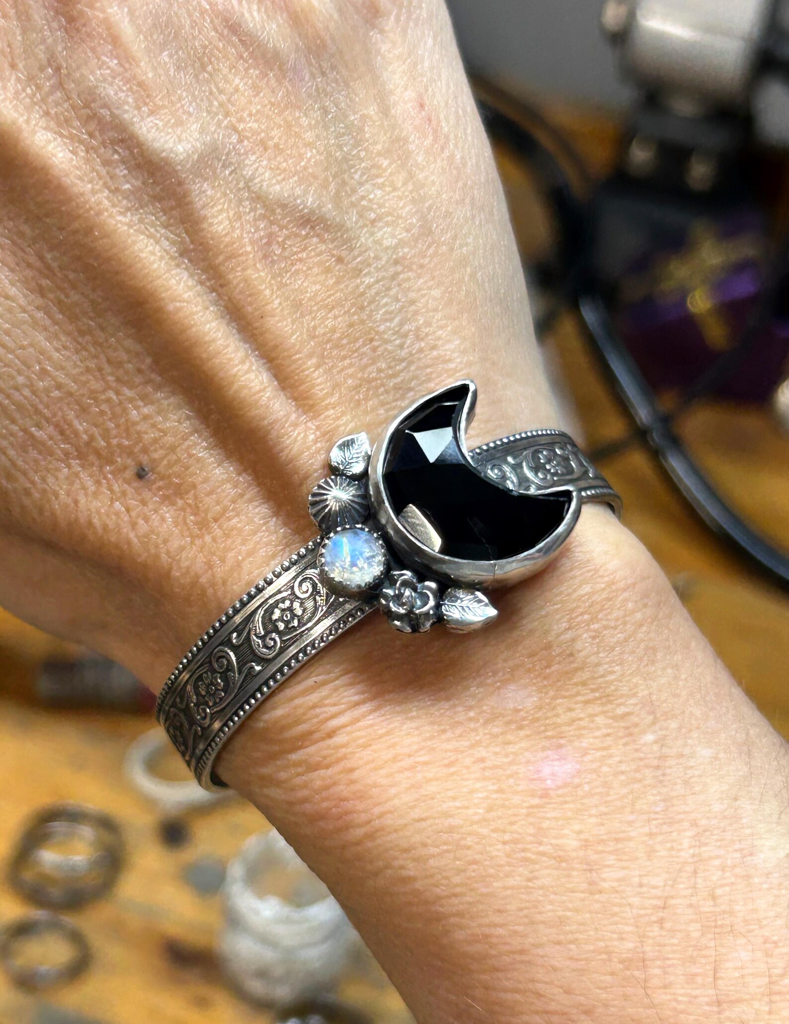 Sterling silver cuff with black onyx moon and moonstone worn on wrist