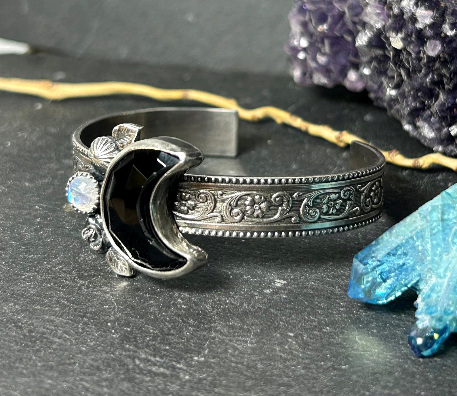 Detailed view of gothic floral cuff with black onyx crescent moon and rainbow moonstone