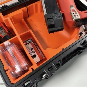 May include: A black and orange hard case with a red and black power tool inside. The case has a foam insert with compartments for the tool and accessories. The tool has a black handle and a red body. The case has a label that says "PORTER CABLE".