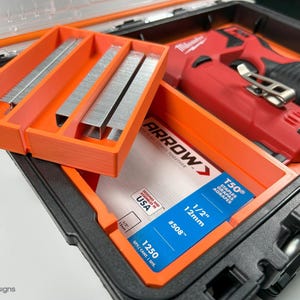 May include: An orange plastic storage case with a red and black electric staple gun and a pack of 1/2 inch staples. The staples are labeled "Arrow" and "T50".