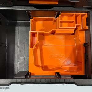 Peut inclure: Une bo&icirc;te &agrave; outils ouverte, noire et grise, avec un organisateur int&eacute;rieur orange. L'organisateur comporte divers compartiments et une base moul&eacute;e. La bo&icirc;te &agrave; outils est con&ccedil;ue pour le stockage et l'organisation des outils.