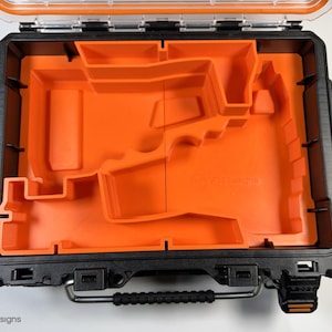 May include: An open black and orange tool case with a custom foam insert. The foam insert has a cutout for a power tool.