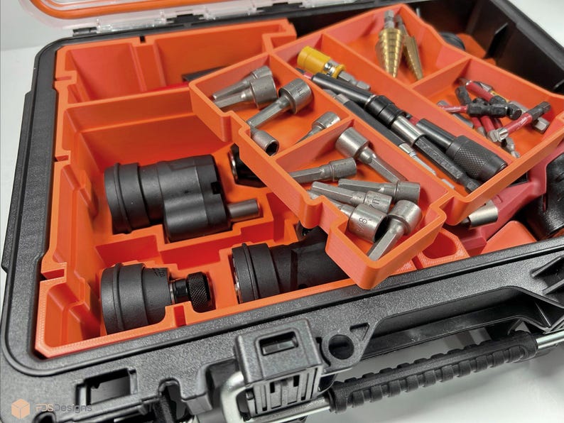 Puede incluir: Una caja de herramientas naranja y negra con una variedad de herramientas y accesorios. La caja tiene una bandeja extra&iacute;ble con m&uacute;ltiples compartimentos para organizar art&iacute;culos peque&ntilde;os. Las herramientas incluyen brocas, destornilladores y otras herramientas peque&ntilde;as.