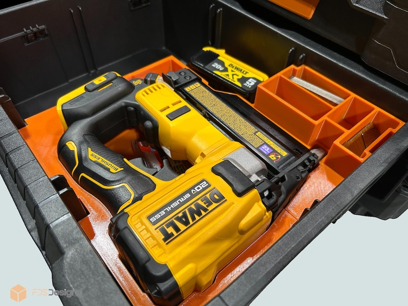 Peut inclure: Un cloueur sans fil DeWalt 20V sans balais jaune et noir avec une poign&eacute;e noire et une batterie, &agrave; l'int&eacute;rieur d'un organisateur d'outils orange et noir. L'organisateur comporte plusieurs compartiments de rangement.