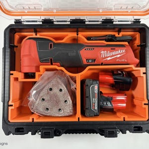 May include: An open black and orange tool case containing a red Milwaukee FUEL oscillating tool, a battery, and sanding pads.