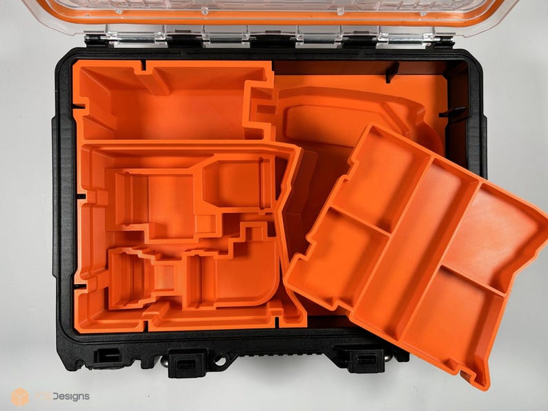 Puede incluir: Una caja de herramientas negra abierta con insertos de espuma naranja. Los insertos est&aacute;n dise&ntilde;ados para contener varias herramientas y accesorios.