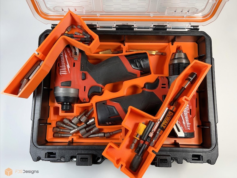 May include: Two orange and black tool organizers with two red and black cordless drills and a variety of drill bits. The organizers are labeled "Milwaukee" and "DeWalt".