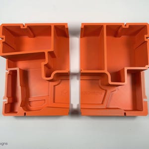 以下が含まれることがあります： 小さなアイテムを整理するための仕切り付きのオレンジ色のプラスチック製収納容器2個。容器は互いに嵌め合うように設計されています。