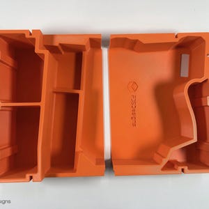 May include: Two orange plastic storage containers with compartments. The container on the right has the text "FDC3D3SIGNS" printed on the side.