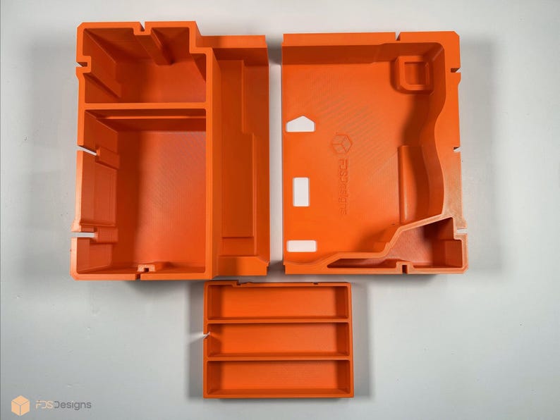 May include: Three orange plastic storage containers with compartments. The containers are designed to fit together to create a larger storage unit.