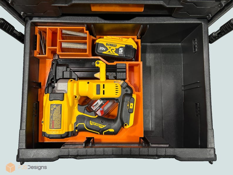 Peut inclure: Une bo&icirc;te &agrave; outils noire et orange avec un cloueur jaune et noir, une batterie et des compartiments de rangement. Le cloueur est un mod&egrave;le sans fil avec une poign&eacute;e noire et un corps jaune. La batterie est &eacute;tiquet&eacute;e "20V" et "5 Ah".