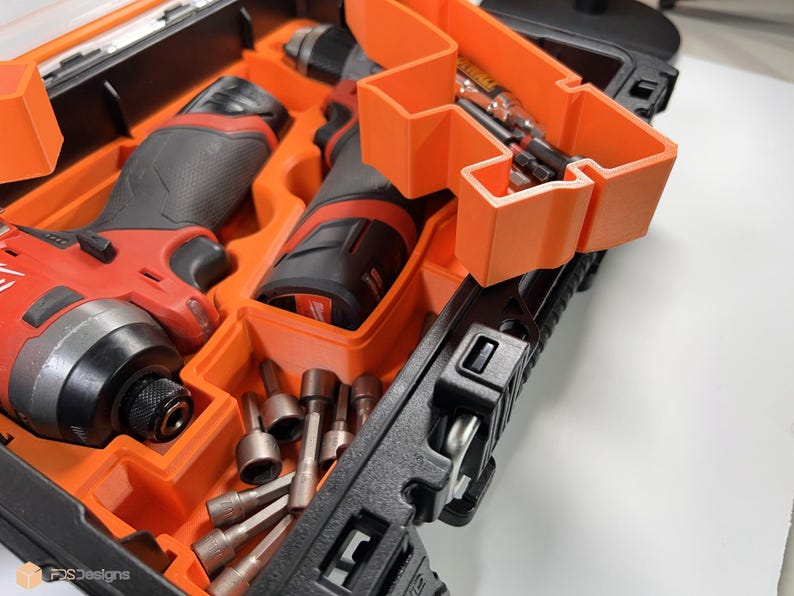 May include: Two red and black cordless power drills with a black and orange carrying case. The drills are in the case with a variety of drill bits.