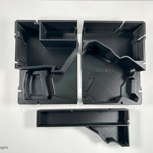 May include: Three black plastic storage containers with different sized compartments. The containers are designed to hold tools or other small objects.