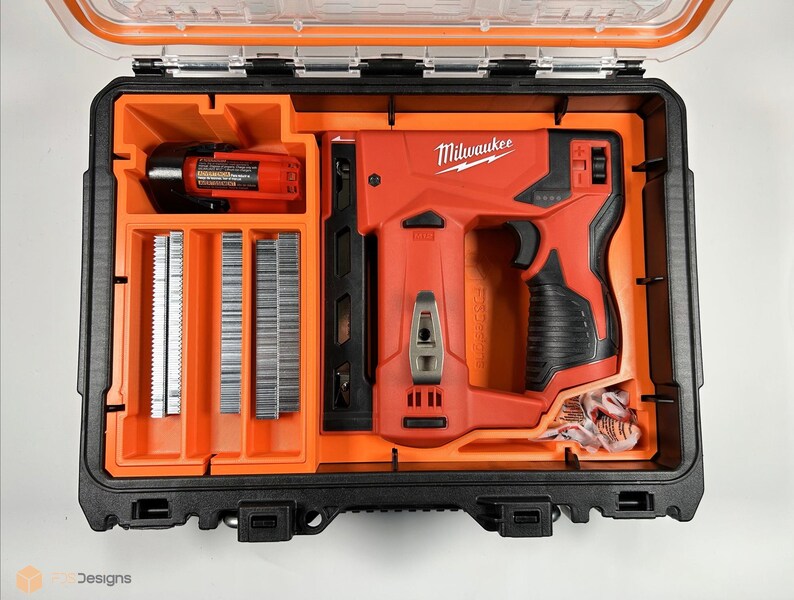 May include: An open orange and black carrying case with a red Milwaukee brand electric staple gun, a black and orange battery, and a compartment with rows of silver staples.