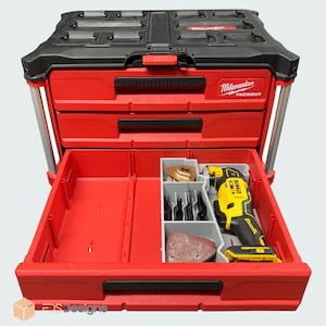 May include: A red and black Milwaukee Packout tool box with multiple drawers and compartments. The open drawer reveals a yellow and black DeWalt multi-tool and various blades and sanding pads. The tool box has a handle and is designed for organization.