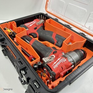 May include: A black and orange tool case with a clear lid, containing red and black power tools and various accessories. The tools are neatly organised within orange compartments.