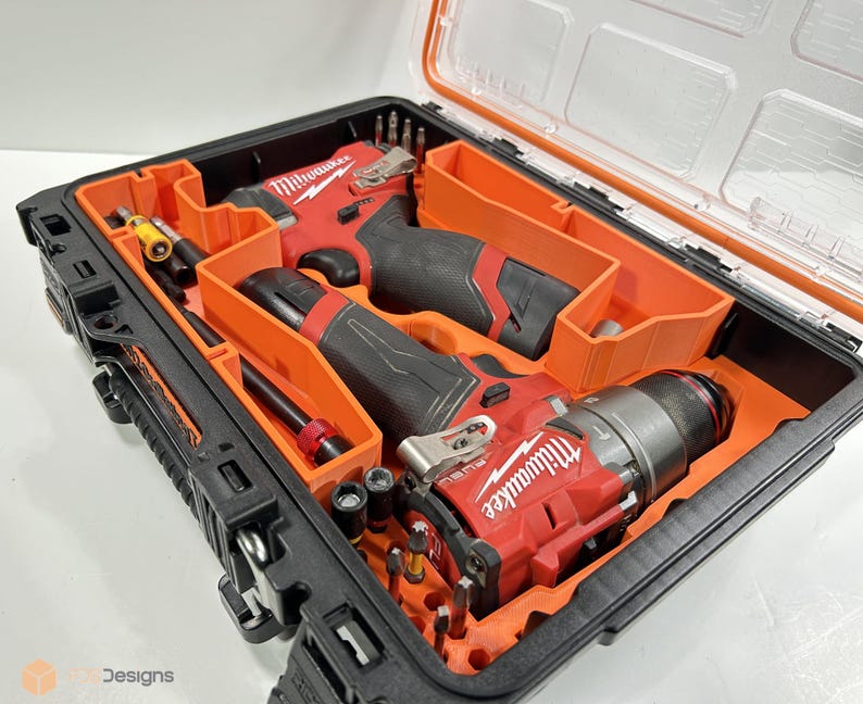May include: A black and orange tool case with a clear lid, containing red and black power tools and various accessories. The tools are neatly organised within orange compartments.