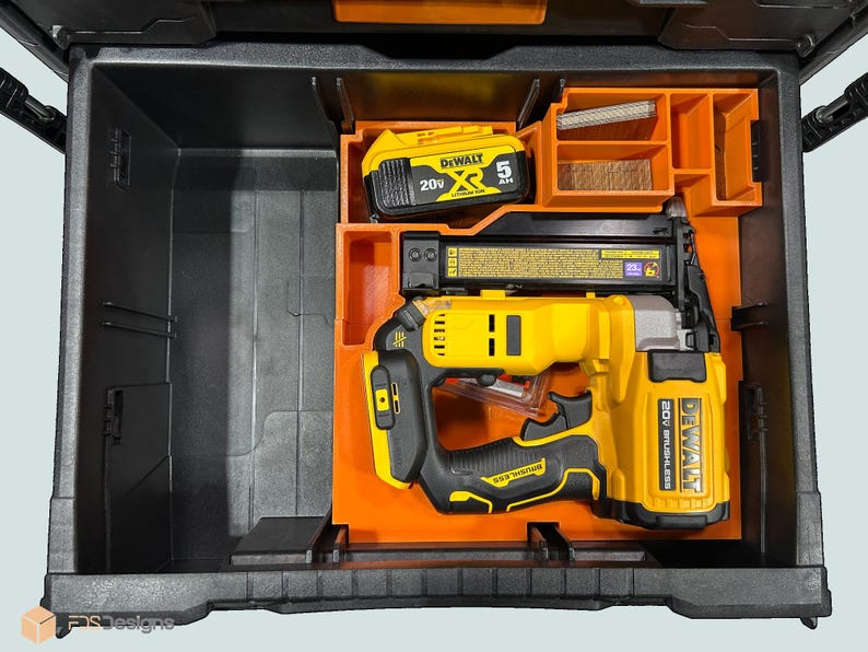 Peut inclure: Une mallette &agrave; outils noire et orange ouverte, contenant un cloueur jaune et noir, une batterie et des compartiments de rangement. Le cloueur porte l'inscription "DEWALT 20V BRUSHLESS".