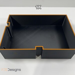 May include: A black rectangular storage tray with orange trim. The tray has a cut-out section on one side and the text "1X" in the top right corner. The logo "FDS Designs" is in the bottom left corner.