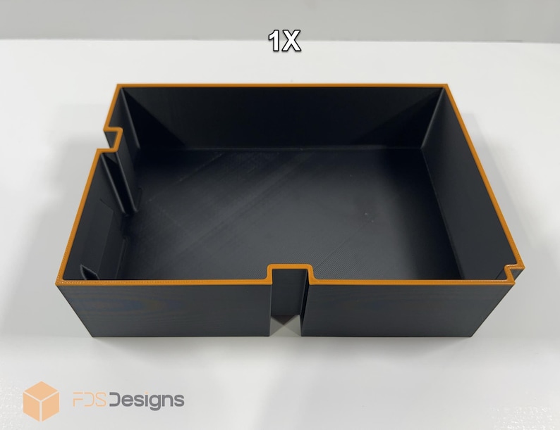 May include: A black rectangular storage tray with orange trim. The tray has a cut-out section on one side and the text "1X" in the top right corner. The logo "FDS Designs" is in the bottom left corner.