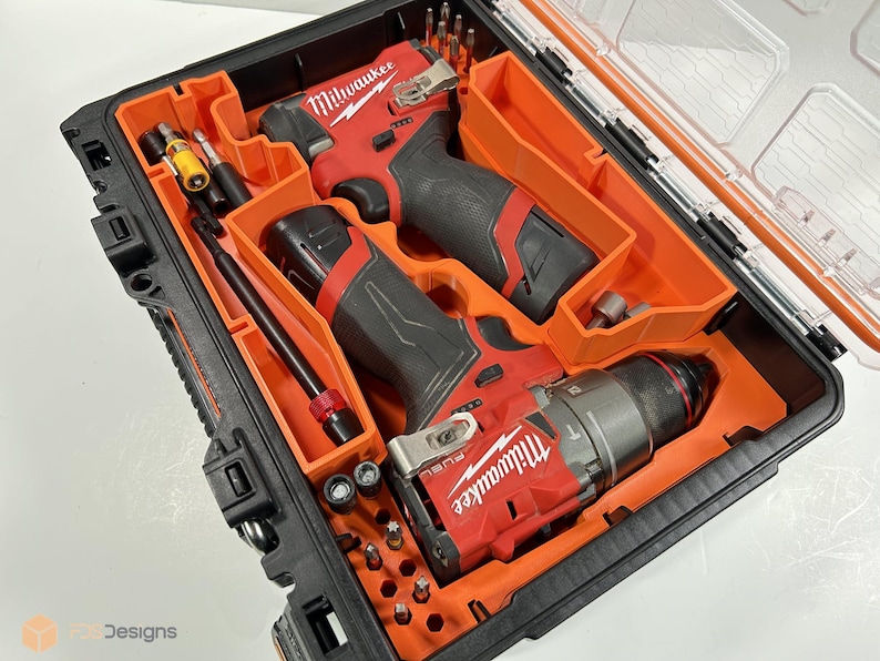 May include: Black and orange tool case containing two red and black power drills and various drill bits. The drills are labelled "Milwaukee" and "FUEL". The case has a clear lid and is designed for tool organisation.