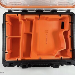 May include: An open black and orange tool case with a foam insert. The insert has multiple compartments and a large cutout for a tool. The case has a clear lid and the text "SCSSSC" is printed on the foam insert.