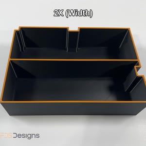 May include: Black storage organizer with orange trim, featuring two compartments and a stepped design. The text "2X (Width)" is visible at the top. The product is from FDS Designs.