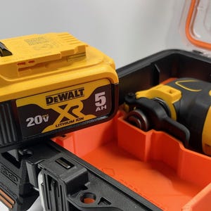 May include: A yellow and black DeWalt XR 20V 5Ah lithium-ion battery is shown next to a yellow and black DeWalt oscillating tool in a black and orange tool case.