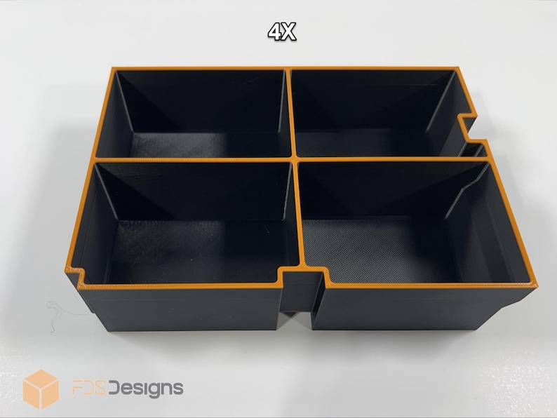 May include: A black and orange organizer with four compartments. The organizer has a rectangular shape with a cutout on one side. The text "4X" is visible at the top.