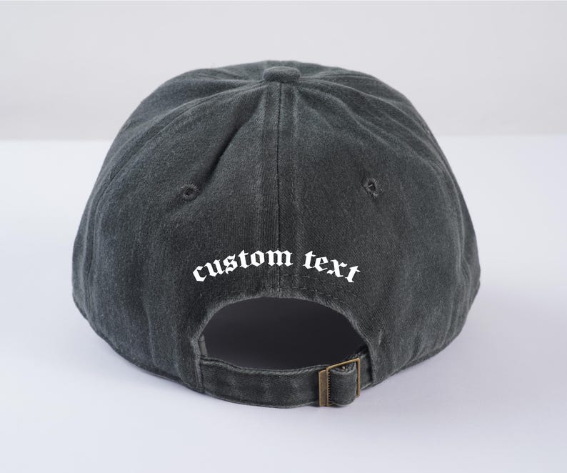 May include: A black baseball cap with a white embroidered text that says "custom text" in a gothic font.