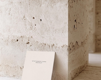 Puede incluir: Una maqueta de tarjeta de papelería blanca con el texto "Stationery Card Mockup" y "Ginger Studio" impreso en ella. La tarjeta está apoyada contra una pared texturizada de color beige claro.