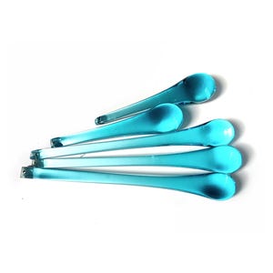 Peut inclure: Six bâtonnets à mélanger en verre turquoise, chacun avec une tête en forme de goutte d'eau et une longue tige fine. Disposés sur fond blanc, ils révèlent leur transparence et leurs nuances de bleu.