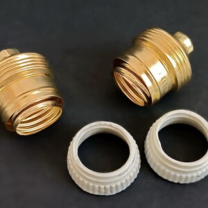 May include: Two gold-coloured light bulb sockets and two white plastic light bulb socket adapters.