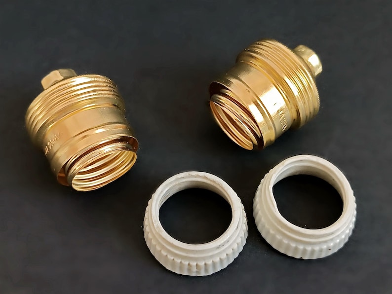 May include: Two gold-coloured light bulb sockets and two white plastic light bulb socket adapters.