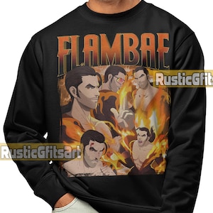 May include: Black sweatshirt featuring a graphic of a man with flames and the word "FLAMBAE" in orange. The graphic has a vintage, comic book style. The sweatshirt is a crew neck style.