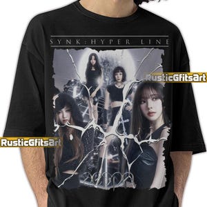 Puede incluir: Camiseta negra con un gráfico de un grupo de mujeres, el texto "SYNK: HYPER LINE" en la parte superior y "aespa" en la parte inferior. La imagen tiene un efecto de cristal roto. La camiseta es de cuello redondo.