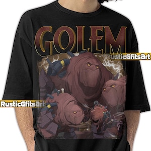 May include: Black t-shirt featuring a graphic of three stylized, reddish-brown golems with glowing yellow eyes. The word "GOLEM" is printed in large, distressed gold letters above the image. The shirt has the text "RusticGfitsArt" printed on it.