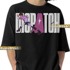 May include: Black t-shirt featuring the word "DISPATCH" in large white letters. A graphic of a character in a purple and white outfit is depicted within the text. The shirt also has the text "RusticGiftsArt".