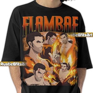 May include: Black t-shirt featuring a graphic design with the word "FLAMBAE" in orange and yellow letters. The design includes multiple illustrations of a man with flames in the background. The artist's name "RusticGfitsArt" is also visible.