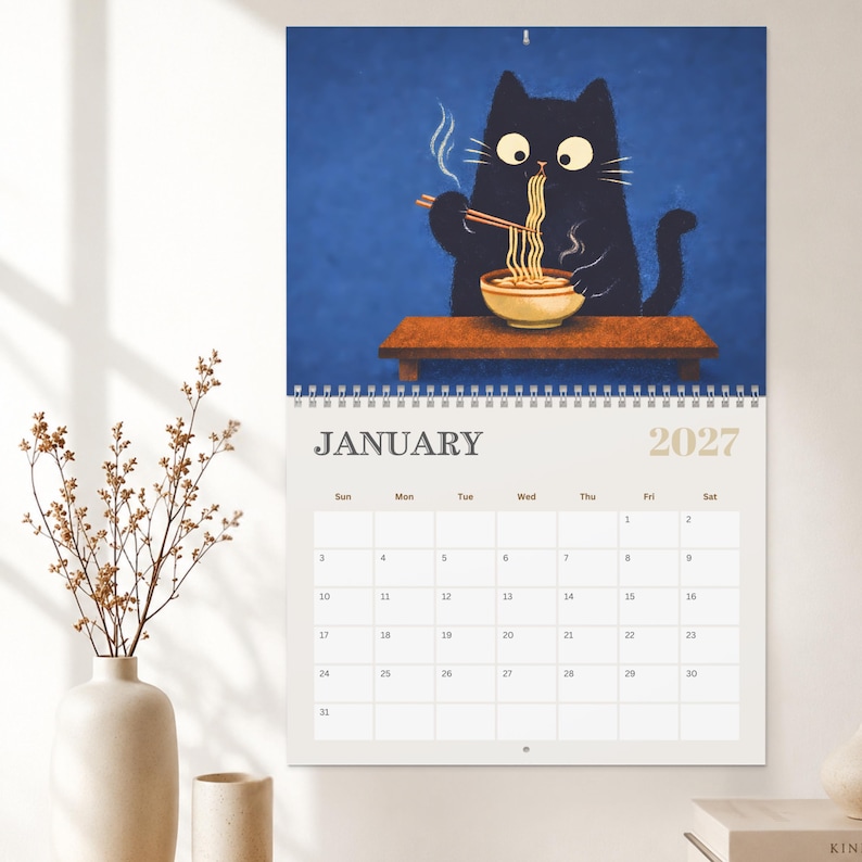 Japanese inspired wall calendar showcasing a playful black cat enjoying ramen, cherry blossoms, moon viewing and seasonal traditions.