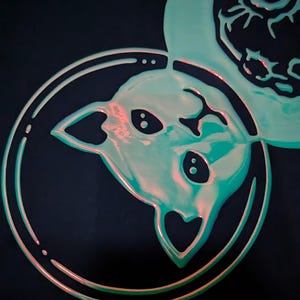 K&ouml;nnte beinhalten: Eine gr&uuml;ne und rosafarbene Katze-Astronauten-Illustration mit einem herzf&ouml;rmigen Kopf, die im Weltraum mit einem Stern und einem Planeten im Hintergrund schwebt. Die Illustration befindet sich auf einem schwarzen Hintergrund. Der Text "jewelrenee.etsy.com" befindet sich am unteren Rand des Bildes.