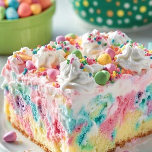 May include: A slice of rainbow cake with whipped cream frosting and colorful sprinkles. The cake is decorated with pastel-colored candy eggs.