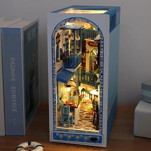 Kit de rincón de lectura "Serenidad junto al mar": Escena de cafetería playera en miniatura con paseo marítimo y luces LED, rompecabezas de madera para decorar estanterías.