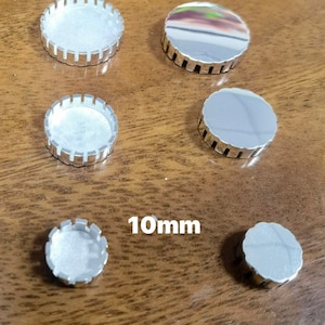 May include: Five silver-coloured metal round discs with scalloped edges. The discs are different sizes, with the smallest disc measuring 10mm in diameter.