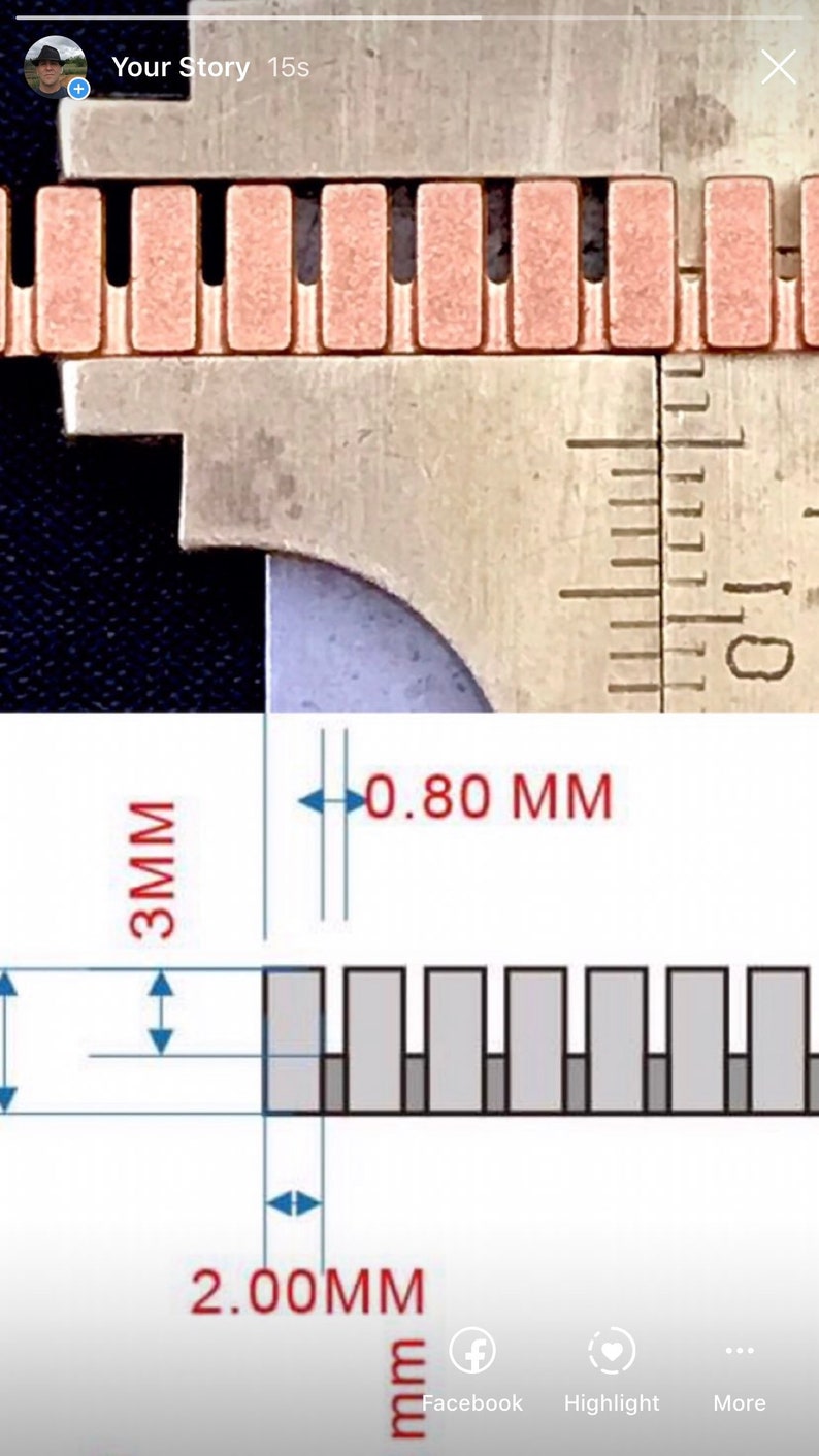K&ouml;nnte beinhalten: Nahaufnahme eines Metalllineals mit einer Messung von 0,80 mm und 2,00 mm. Das Lineal wird verwendet, um die Breite einer Reihe kleiner, rechteckiger, kupferfarbener Objekte zu messen.