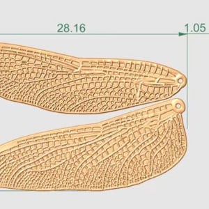 May include: A detailed illustration of two golden-colored, stylized dragonfly wings, each with intricate vein patterns. The wings are approximately 1.05 inches thick, 17.97 inches tall, and 28.16 inches wide. The design includes a small hole for hanging.